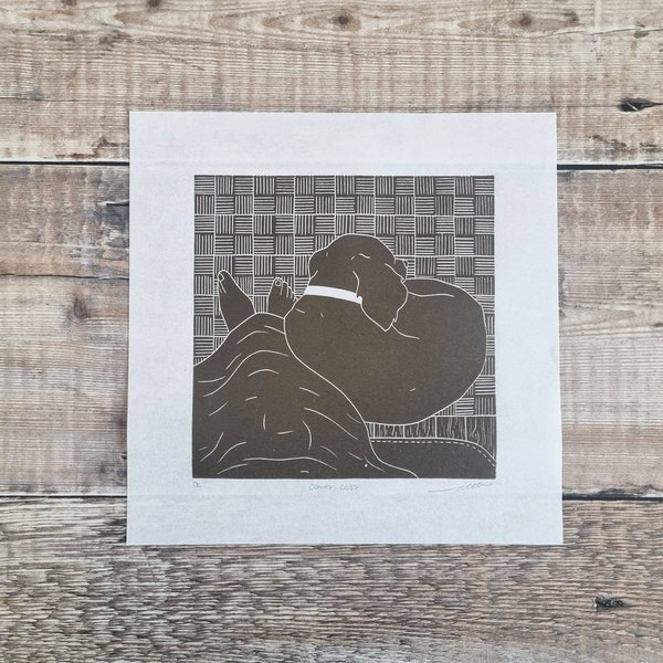 Comfy Cosy - Original linocut print of  a dog curled up by the owners feet on a cosy night in