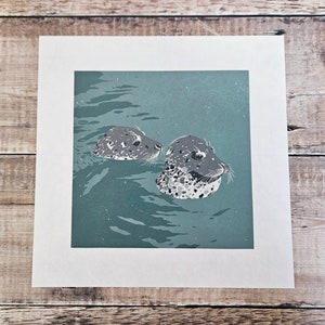 Original limited edition reduction linocut print of a two seals in popping their heads out of the water (24)