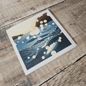 Pu&ograve; includere: Una stampa artistica quadrata raffigurante un paesaggio stilizzato con un corpo d'acqua blu scuro e un cielo colorato. Forme circolari bianche e gialle sono sparse sull'immagine. La stampa ha un bordo bianco.