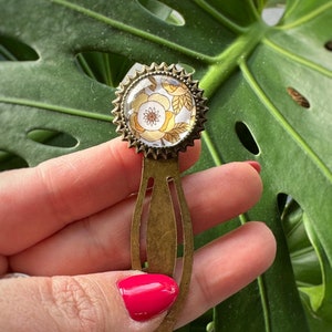 Bladwijzer bronzen paperclip en ronde glazen cabochon bedrukte kaki gele bloemen uniek en origineel handgemaakt ideaal voor cadeau