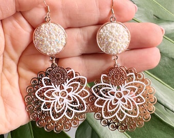 手作りのボヘミアンシックなコスチュームイヤリング。繊細で軽量なデザインで、ホワイトゴールドとローズゴールドのラインストーンカボションとユニークな手作りのペンダントが特徴です。