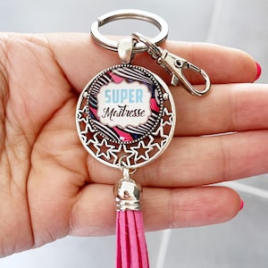 Porte clé argenté et rose avec cabochon «super maîtresse » avec pompon rose unique fait main idéal cadeau fin année scolaire