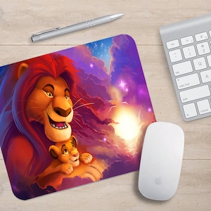 Op de afbeelding: Een kleurrijke muismat met een cartoon afbeelding van Simba en Mufasa uit de Disney-film The Lion King. De afbeelding toont de twee leeuwen tegen een achtergrond van een paarse en oranje zonsondergang met sterren aan de hemel.