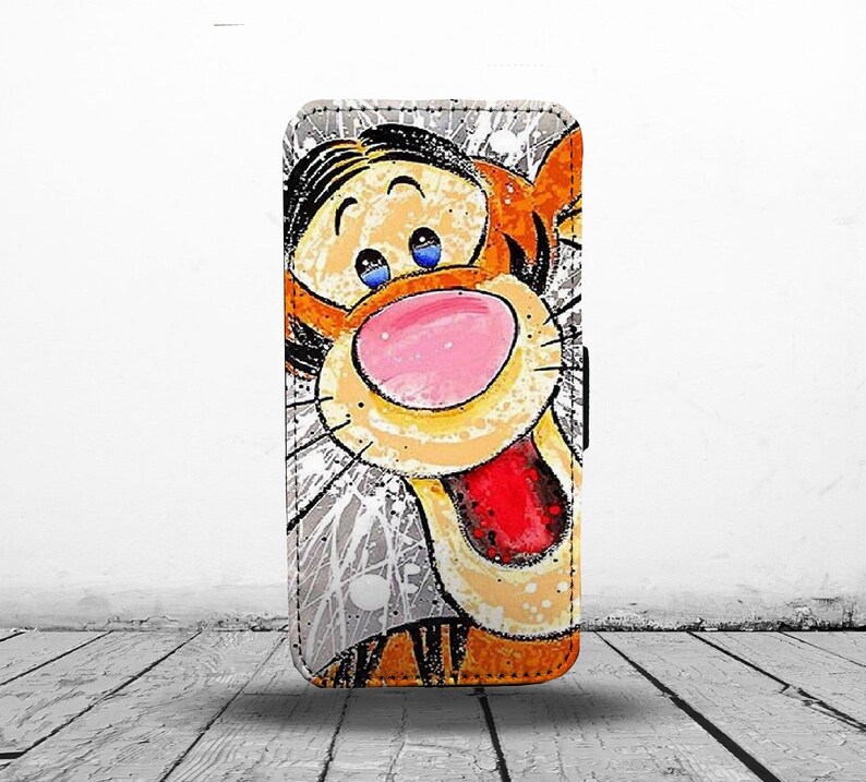 May include: A colorful phone case with a cartoon illustration of Tigger from Winnie the Pooh. The case has a white background with orange, yellow, red, and blue paint splatters.