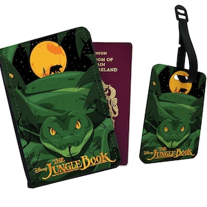 May include: A green passport holder and luggage tag featuring a green snake with yellow eyes, a full moon, and the text "Disney The Jungle Book".