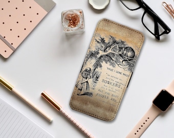 Può includere: Una custodia per telefono in pelle beige con un'illustrazione in bianco e nero di Alice nel Paese delle Meraviglie. Presenta la citazione: "Sono diventato pazzo?" e "Bonkers". La custodia è su una superficie bianca con cancelleria.