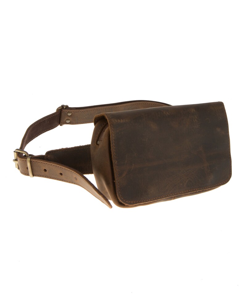 Peut inclure: Une banane en cuir marron avec une fermeture &agrave; boucle et une poche zipp&eacute;e. Le sac se porte &agrave; la taille.