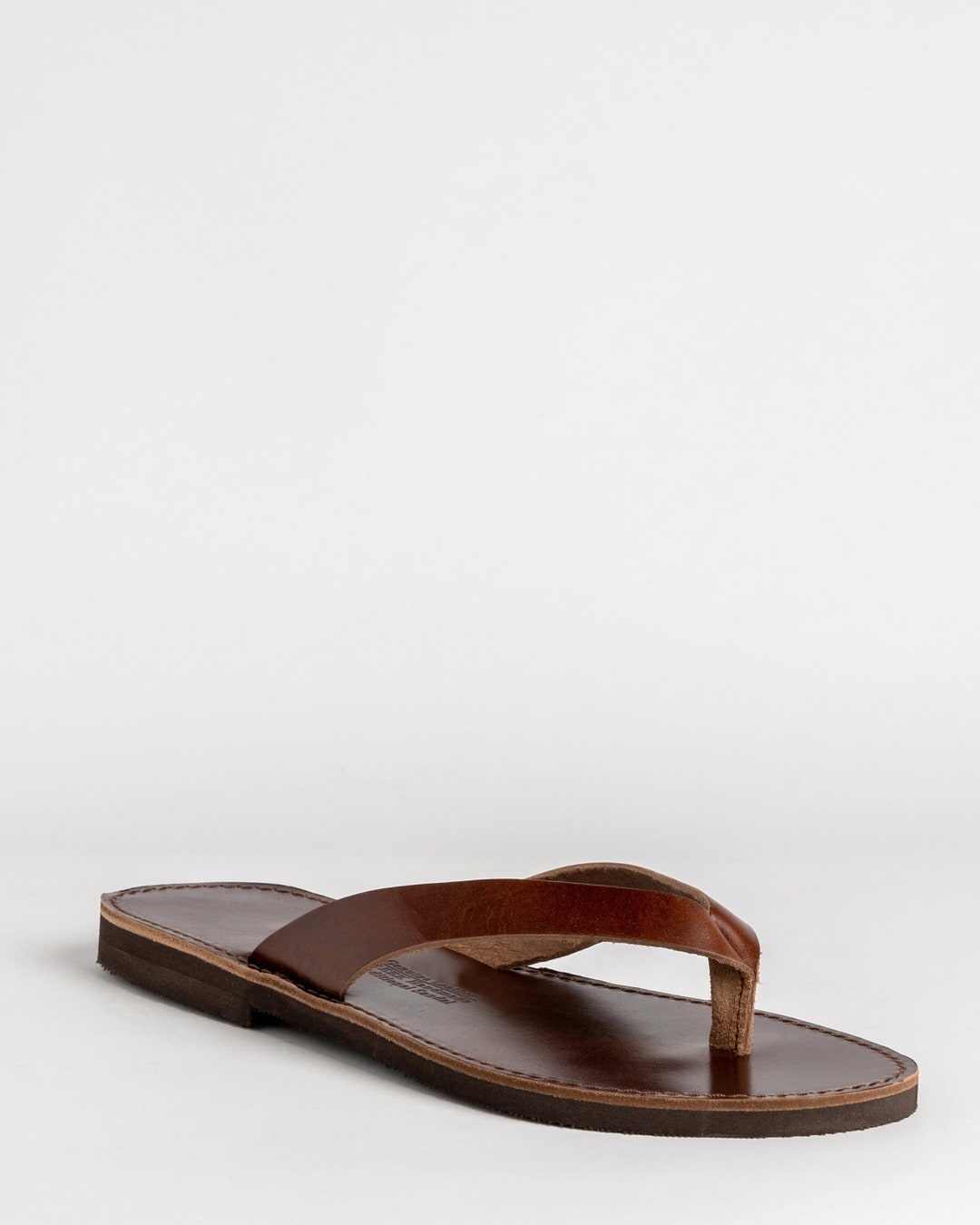 【MODERNIF】Toffee Leather Flip Flops Tkees Women's Foundations Matte Flip Flop | $60.00 | Saint
