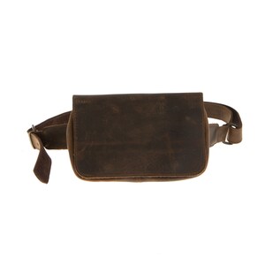 Peut inclure: Une banane en cuir marron avec une fermeture &agrave; boucle et une sangle. Le sac a un aspect vieilli et est fait d'un cuir &eacute;pais et r&eacute;sistant.