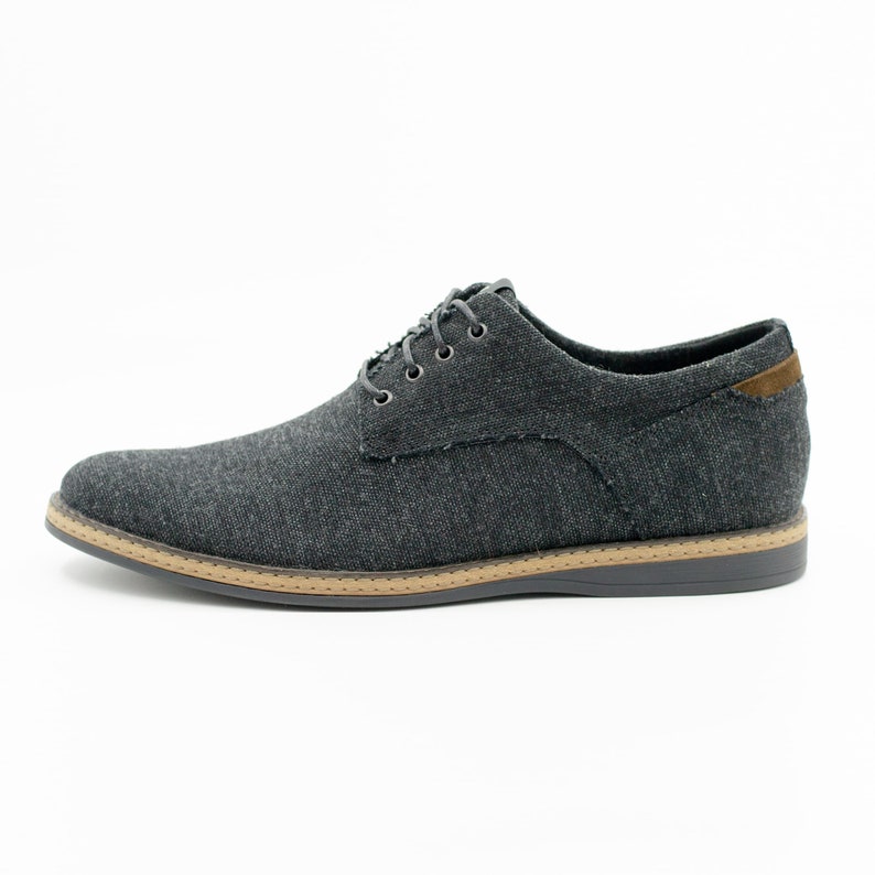 May include: A pair of dark gray canvas lace-up shoes with a brown rubber sole.