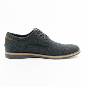 May include: A pair of dark gray canvas lace-up shoes with a brown sole.