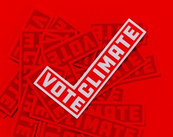 May include: A red background with a white checkmark sticker that says "Vote Climate". The sticker is on top of a pile of red stickers that say "Vote Climate".