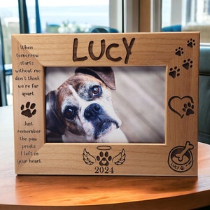 May include: A wooden pet memorial photo frame with a paw print design. The frame has a photo of a dog and the text "When tomorrow starts without me don't think we're far apart. Just remember the paw prints I left in your heart. LUCY 2024" is engraved on the frame.