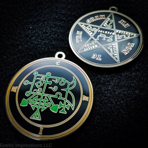 May include: Two black metal pentagram charms with gold trim. One charm features a green sigil and the words "TRAI GRAM MAH", "SOLUZEN", "VELLIAION", "IG", and "NON". The other charm features a green sigil and the letters "M", "I", and "C".
