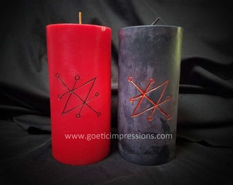 Può includere: Due candele a colonna, una rossa e una grigio scuro, con sigilli scolpiti. La candela rossa ha uno stoppino dorato e la candela grigio scuro ha uno stoppino nero. L'indirizzo del sito web "www.goeticimpressions.com" è stampato sulla candela rossa.
