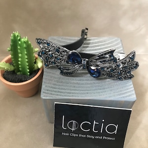 Loctia lined no slip metal bow with blue rhinestones stays in place
