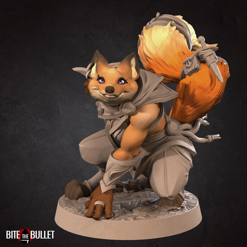 May include: A small, orange fox figurine with a bushy tail, wearing a grey and white outfit. The figurine is posed in a crouching position with its right paw extended forward. The figurine has purple eyes and a friendly expression.