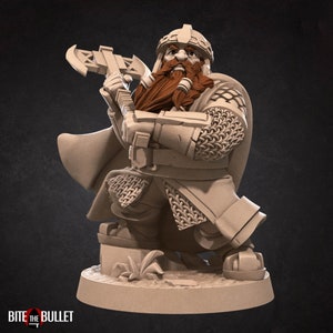 K&ouml;nnte beinhalten: Eine beige Miniaturfigur eines b&auml;rtigen Zwergenkriegers mit Helm und Kettenr&uuml;stung, der eine doppelseitige Streitaxt h&auml;lt. Die Figur steht auf einem runden Sockel, wobei der Text BITE THE BULLET in der unteren linken Ecke abgedruckt ist.