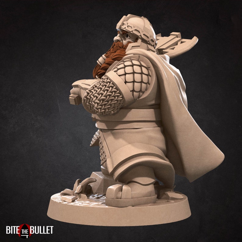 K&ouml;nnte beinhalten: Eine Miniaturfigur eines b&auml;rtigen Kriegers mit Helm, Kettenhemd&auml;rmeln und Umhang, der eine Axt auf dem R&uuml;cken tr&auml;gt. Die Figur ist in einem hellen Beigeton gehalten, hat einen braunen Bart und zeigt den Text BITE THE BULLET an der Basis.