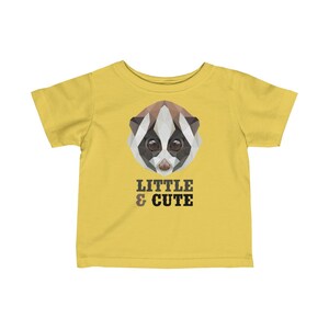 May include: Yellow toddler t-shirt featuring a geometric illustration of a lemur's face and the text "LITTLE & CUTE".