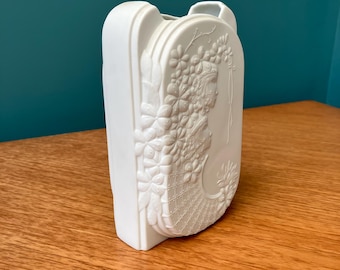 A Matt White Porcelain Vase Decorated with Flower Power Children and Flowers