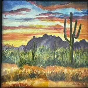 May include: A watercolor painting of a desert landscape with a mountain range in the background, a large saguaro cactus in the foreground, and a sunset sky with orange, yellow, and blue hues.
