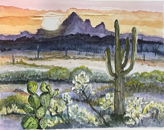 May include: A watercolor painting of a desert landscape with a large saguaro cactus in the foreground. The cactus is green with a brown trunk and is surrounded by smaller cacti and bushes. In the background, there are purple mountains and a sunset sky.