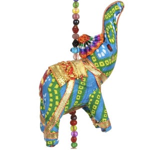 May include: A decorative elephant ornament with a blue and green patterned design, accented with gold trim and colourful beads. The elephant has a raised trunk and is suspended from a string of beads.