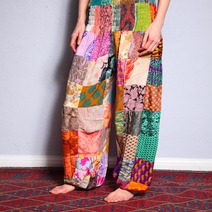 May include: Patchwork trousers with a colourful, multi-coloured design. The trousers are made of different fabrics and have a loose, flowing fit.