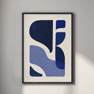 May include: A framed wall art print featuring an abstract composition of organic shapes in varying shades of navy, royal, and light blue against a cream background. The design includes textured surfaces and vertical line patterns within the blue forms.