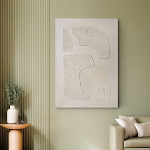 May include: A rectangular wall art piece featuring a cream-colored surface with raised, textured abstract shapes. The composition includes smooth, rough, and linear grooved patterns arranged in a balanced, non-representational arrangement.