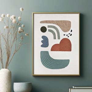 May include: A framed wall art print featuring abstract shapes in beige, sage green, blue, and terracotta on a white background. The composition includes textured curved lines, a solid circle, and small black dots, all enclosed in a thin gold frame.