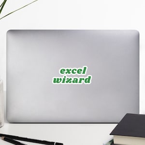 May include: A silver laptop with a green sticker that says "excel wizard" on the back.