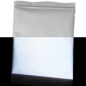 Puede incluir: Un sobre blanco con una superficie reflectante plateada. El sobre est&aacute; sellado y tiene una solapa en la parte superior.