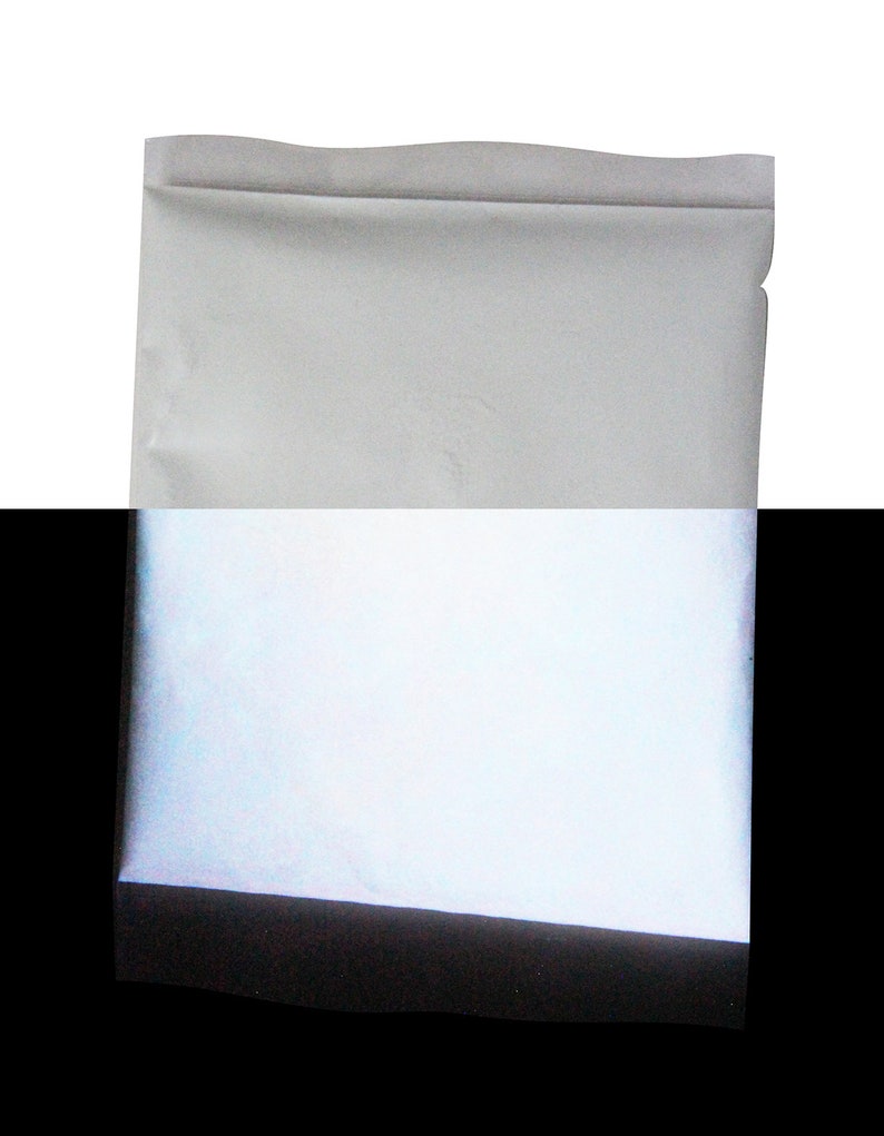 Puede incluir: Un sobre blanco con una superficie reflectante plateada. El sobre est&aacute; sellado y tiene una solapa en la parte superior.