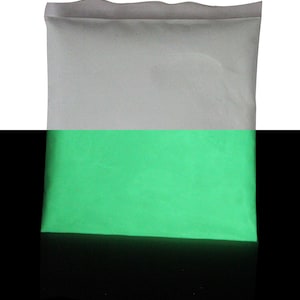 Puede incluir: Una bolsa blanca llena de polvo verde brillante que brilla en la oscuridad.