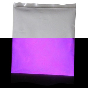 Puede incluir: Una bolsa de pl&aacute;stico blanca llena de polvo morado brillante. El polvo brilla en la oscuridad.