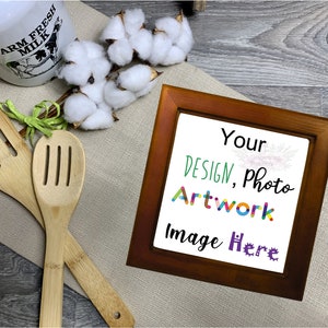 May include: A brown wooden picture frame with a white background. The text "Your Design, Photo Artwork Image Here" is written in colorful letters on the white background.