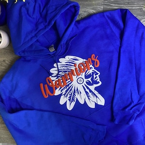 May include: A royal blue hooded sweatshirt with a white and red graphic of a Native American headdress and the word "Warriors" in red.