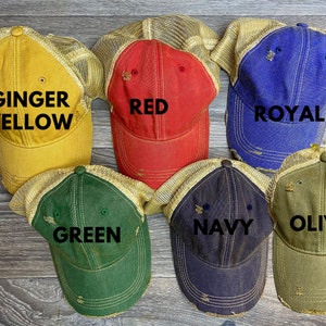 May include: Six different colored trucker hats with mesh back panels. The hats are labeled with the colors: Ginger Yellow, Red, Royal, Green, Navy, and Olive.