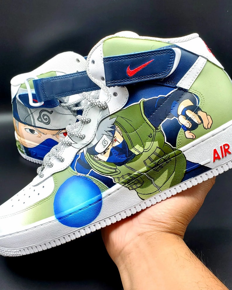 May include: White high-top sneakers with a green, blue, and black design featuring the anime character Naruto. The sneakers have a blue swoosh logo on the side and the word "AIR" on the back.