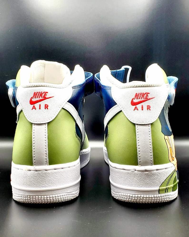 May include: A pair of blue and green high-top sneakers with white soles and a white swoosh logo. The sneakers have a strap across the top and the words "Nike Air" are printed on the back of each shoe.