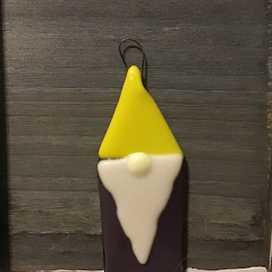 May include: A glass ornament shaped like a gnome with a yellow hat, white beard, and purple body.