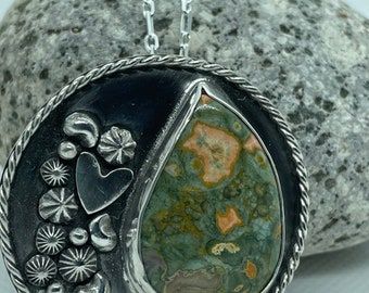 Rhyolite set in medallion pendant with embellishments