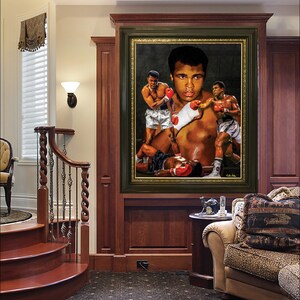 May include: A framed print of a painting depicting a boxing scene with three boxers. The main boxer is in the center of the image and is wearing red boxing gloves. The print is hanging on a wall in a home interior setting.