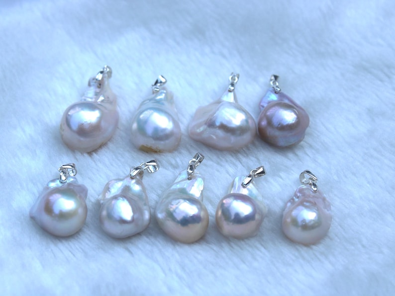 May include: A collection of eight iridescent white baroque pearl pendants with silver clasps. The pearls are various shapes and sizes.
