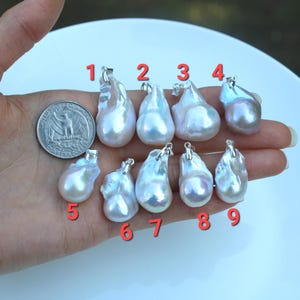 May include: Nine white and iridescent baroque pearl pendants with silver bail, numbered 1 through 9.