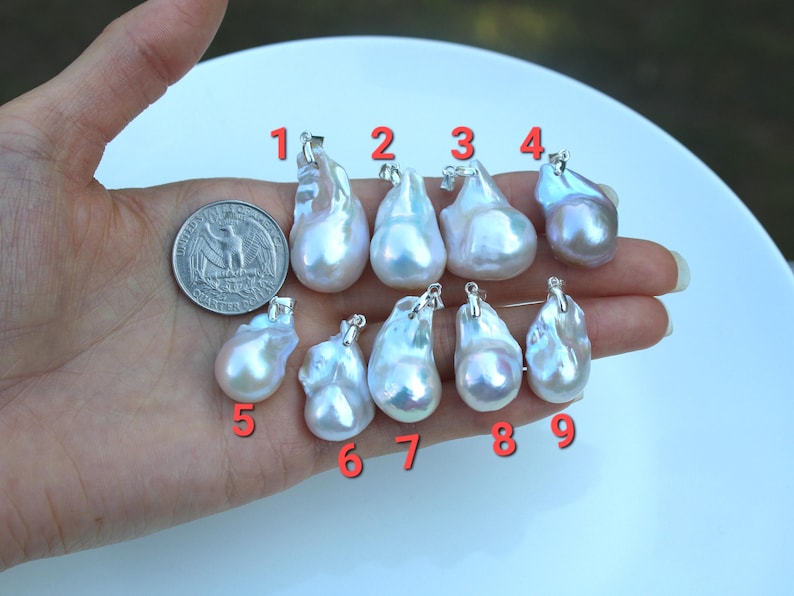 May include: Nine white and iridescent baroque pearl pendants with silver bail, numbered 1 through 9.