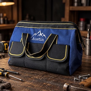Puede incluir: Una bolsa de herramientas azul y negra con un gráfico de montaña blanco y el nombre Austin impreso en el frente. La bolsa tiene asas de tela negra, un cierre de cremallera superior y tres bolsillos exteriores con bordes amarillos.