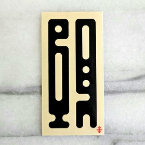 May include: A black and white sticker with two abstract shapes. The shapes are geometric and resemble a person with a key.